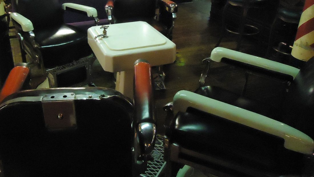 A row of cast-iron reclining barber chairs