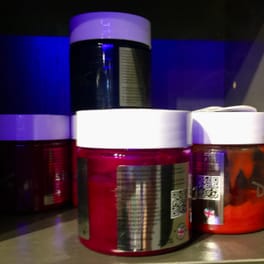 Salon detail: jars of semi-permanent hair colour on a salon shelf.