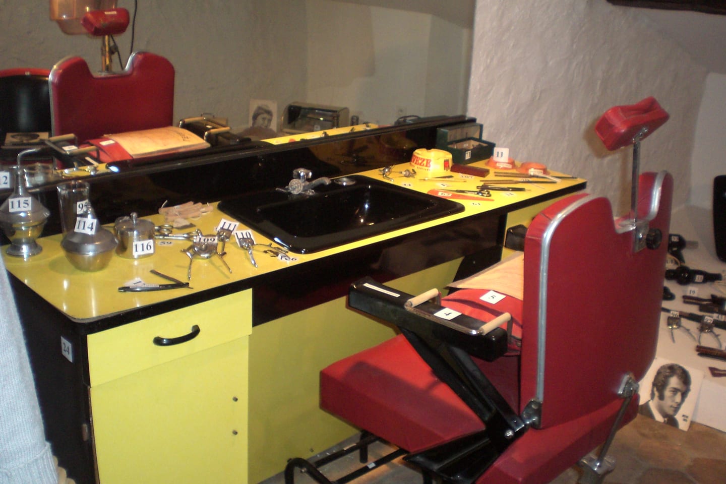 A working counter with combs, scissors and clippers laid out beside a barber chair.