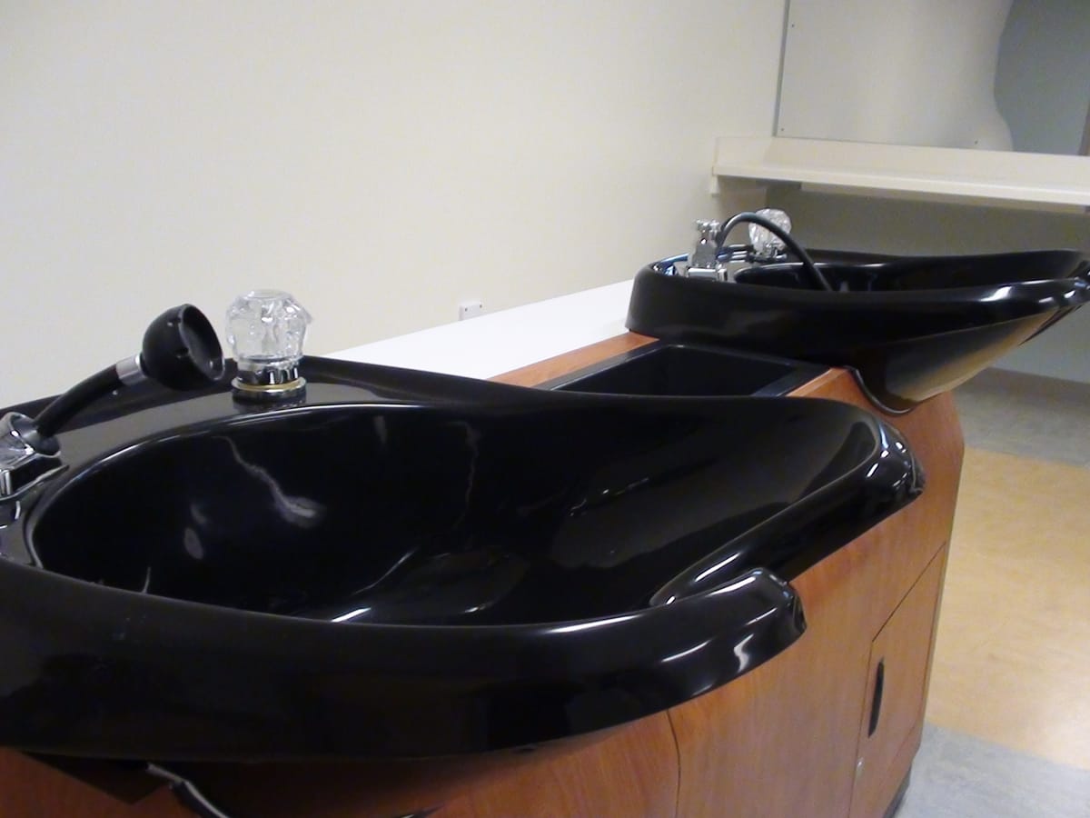 Inside a working hair salon: styling chairs, mirrors and a counter under bright ceiling lights.