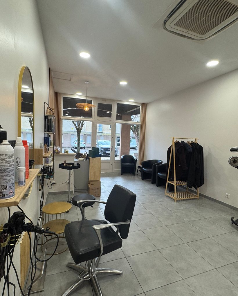 A styling station with a round mirror, a chair and window light