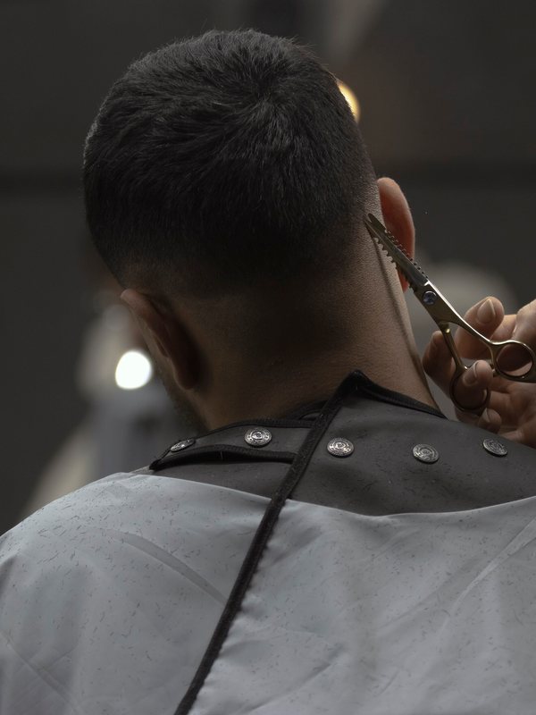 Shears trimming the hair at the nape of a client&rsquo;s neck