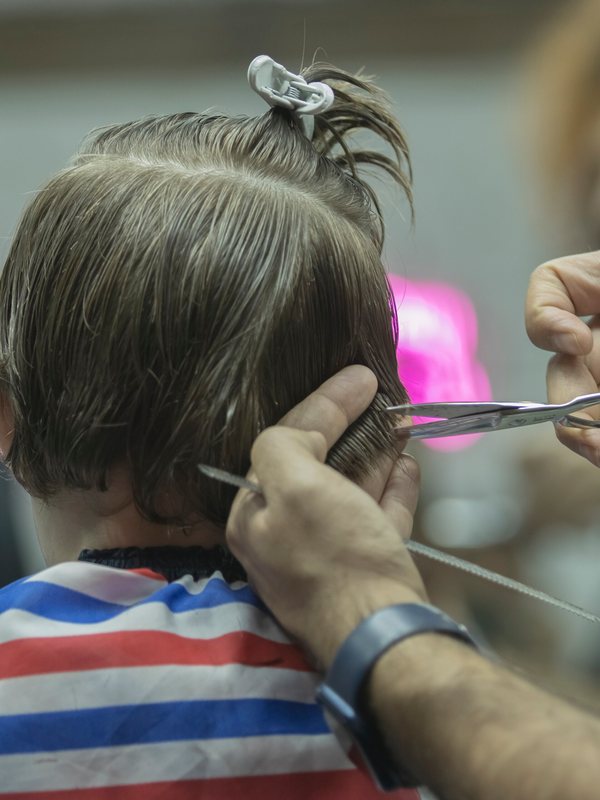 A final comb-through and scissor check at the back of the head