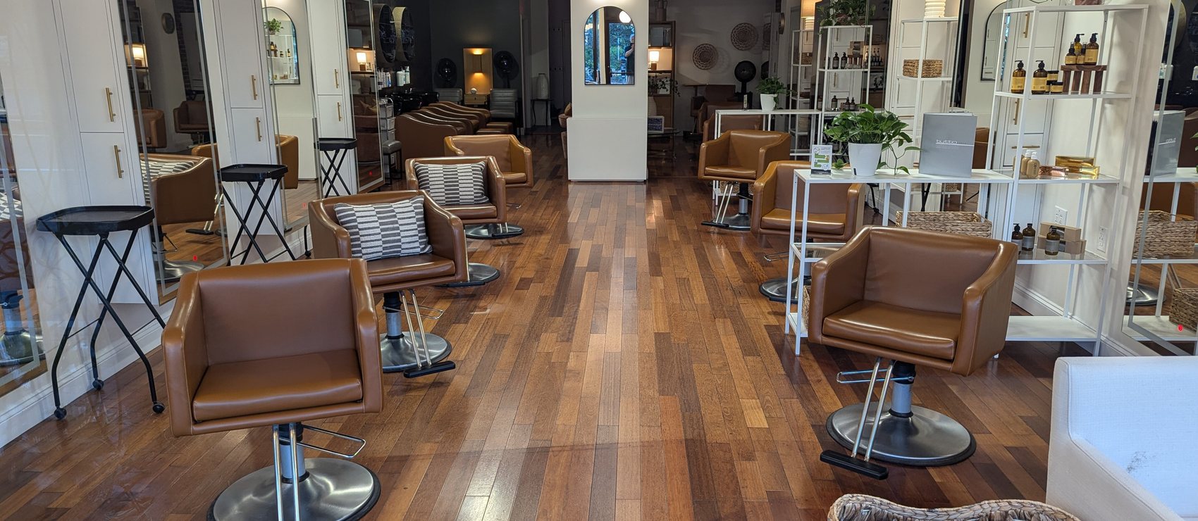 The studio floor: styling chairs and round mirrors along a pale timber room
