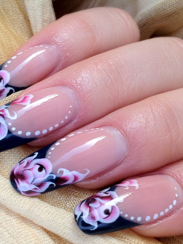 A finished set of almond nails with hand-painted florals and a dotted outline.