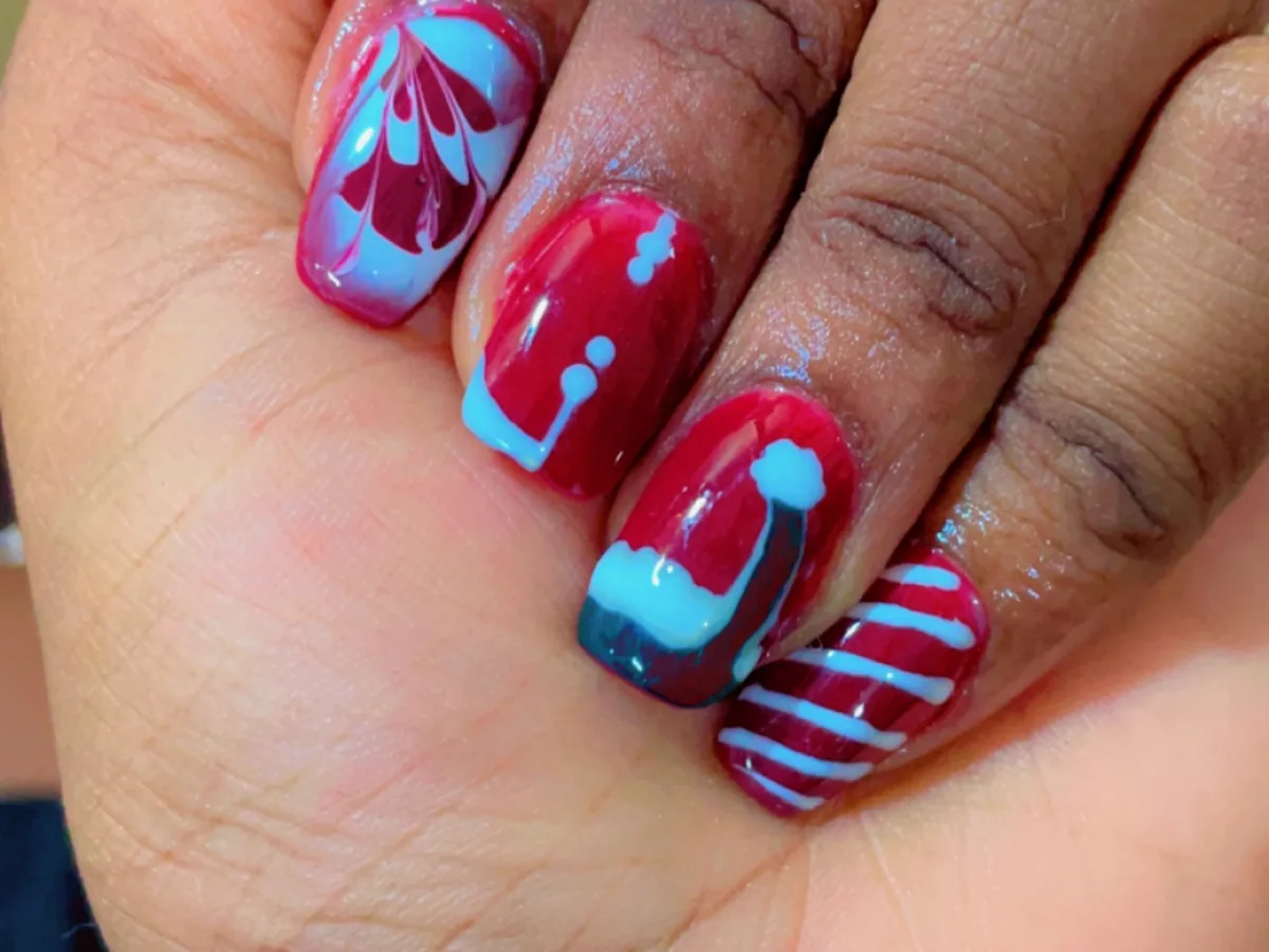 Freehand pink and blue nail art across a full gel set