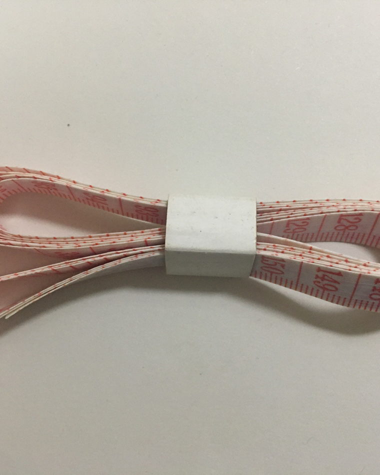 A soft measuring tape marked in centimetres, coiled loosely.