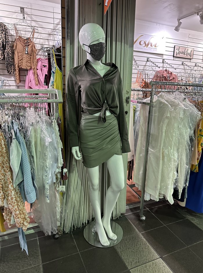 A dress form wearing a sequinned mask and evening dress