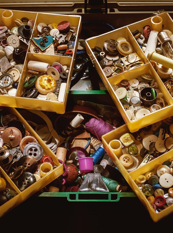 A box filled with loose sewing buttons