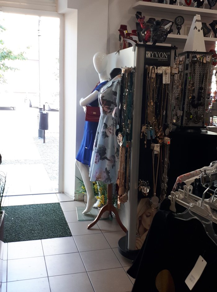 The floor of a small clothing boutique, rails and shelves