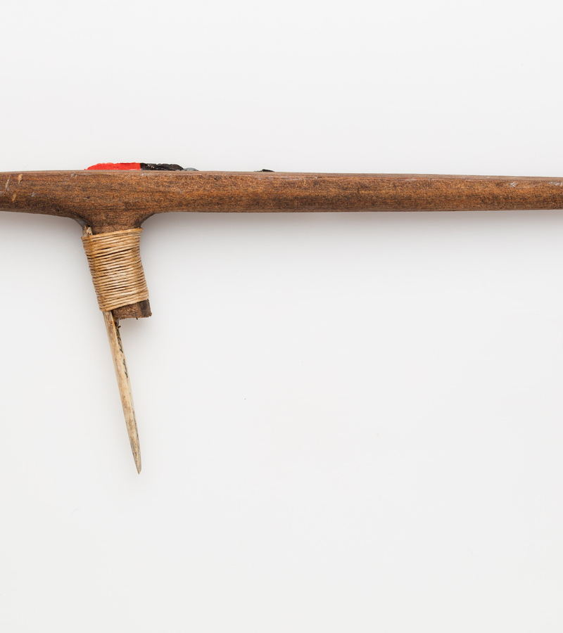 A carved uhi chisel laid flat on a white ground.