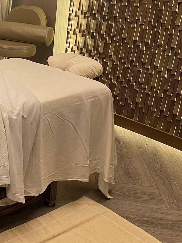 Quiet lounge with a draped treatment bed and soft lighting