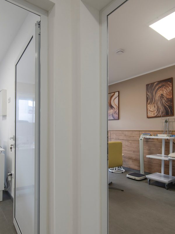 Consulting desk seen through a doorway, with a treatment room beyond