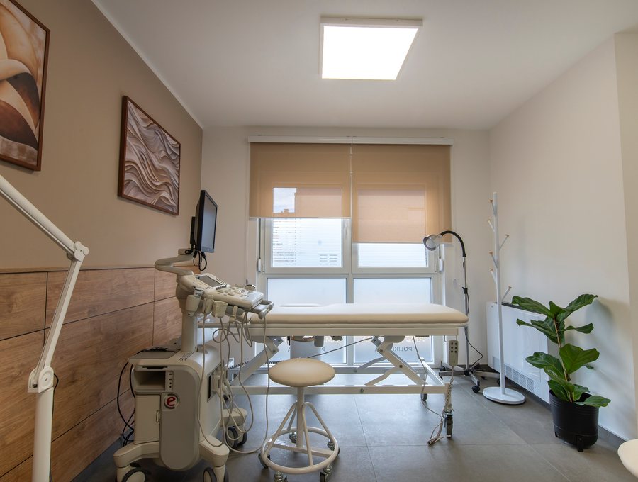 Examination room with a treatment couch, monitor and shaded window