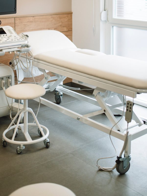 The treatment couch and rolling stool beside the ultrasound trolley