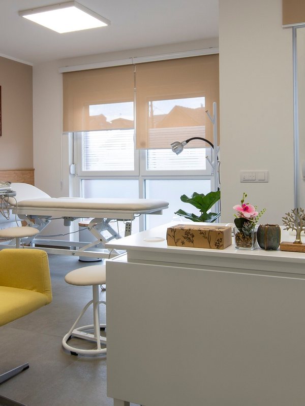 Trolley of skincare products beside the MedSpa couch, with daylight through the blind
