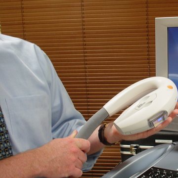 A clinician holding a laser handpiece in the MedSpa treatment room