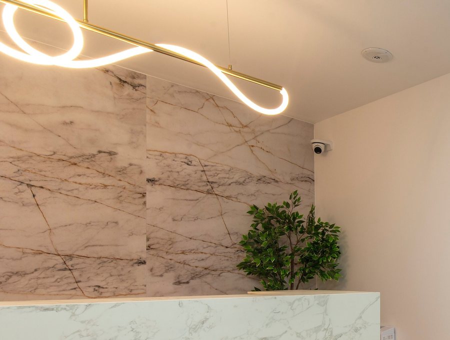 The reception counter, finished in marble with a ring pendant light above