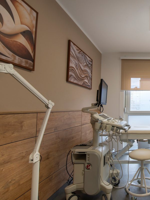 Examination room with a treatment bed and a wall monitor