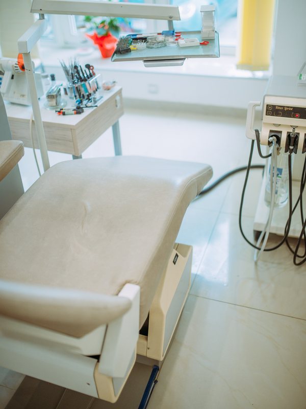 Treatment chair with an overhead lamp and an instrument trolley
