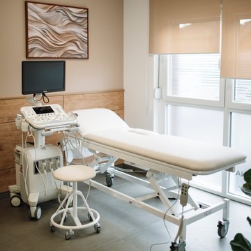 Examination room with an ultrasound console and a treatment bed
