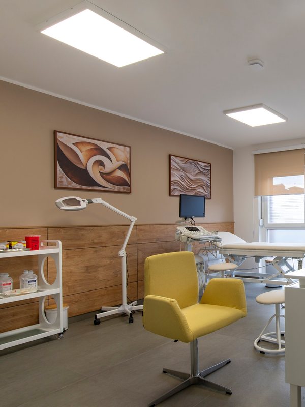 Treatment couch and magnifying lamp in a bright clinic room
