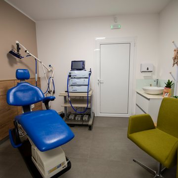 Treatment room with a reclining chair and an equipment trolley