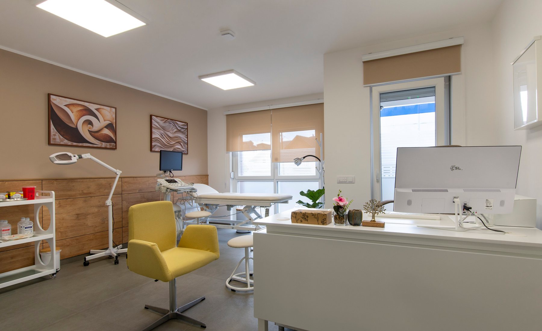 Bright treatment room with a magnifying lamp and a treatment couch