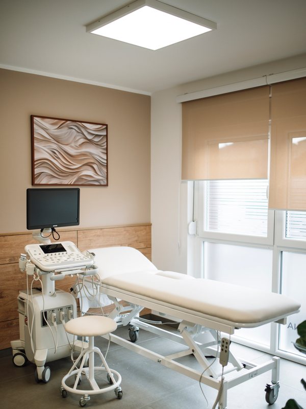Framed artwork and a monitor above a treatment bed