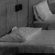 A made-up bed with a pillow in a black-and-white treatment room.