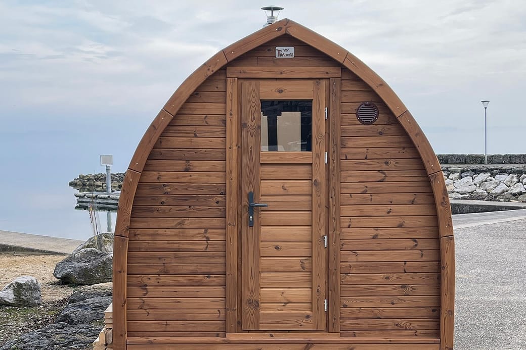 A timber sauna cabin at the end of a short path.