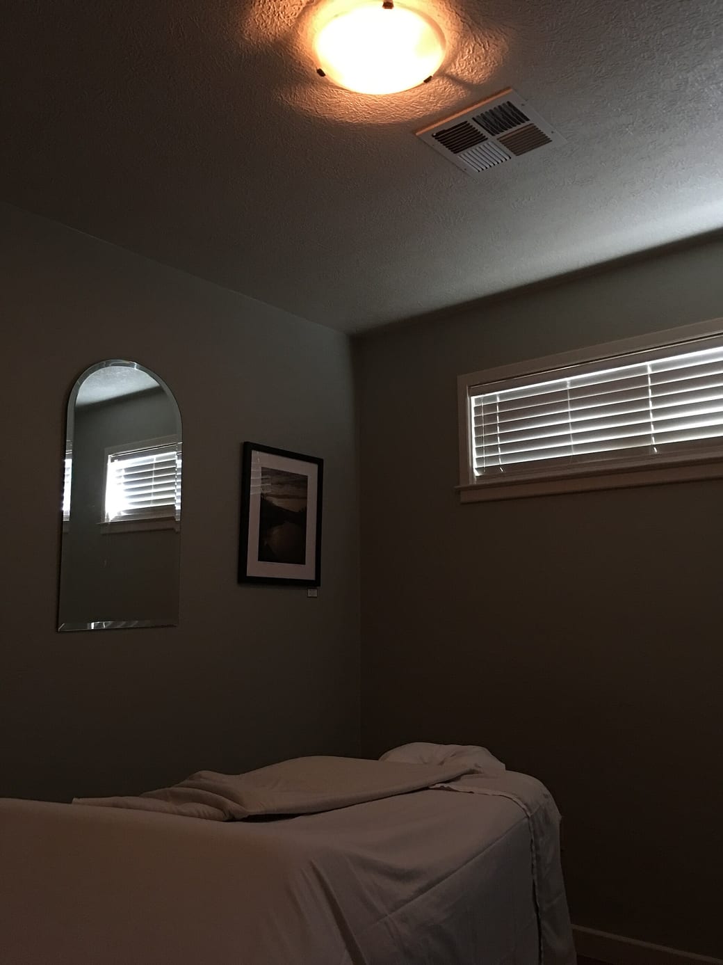 A made-up treatment table under a shuttered window.