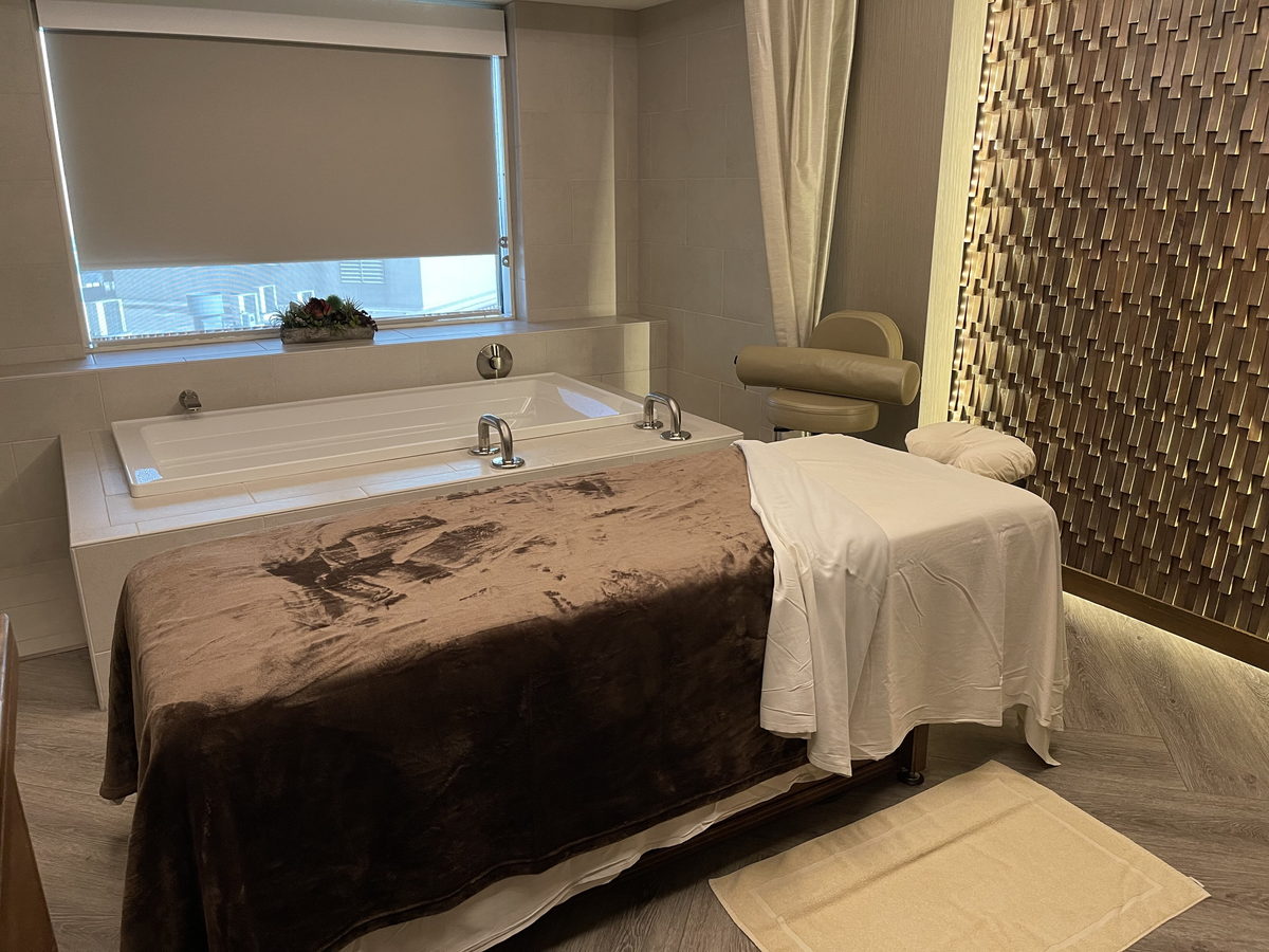 A spa lounge in soft daylight, with low seating and pale walls, photographed with nobody in the room.