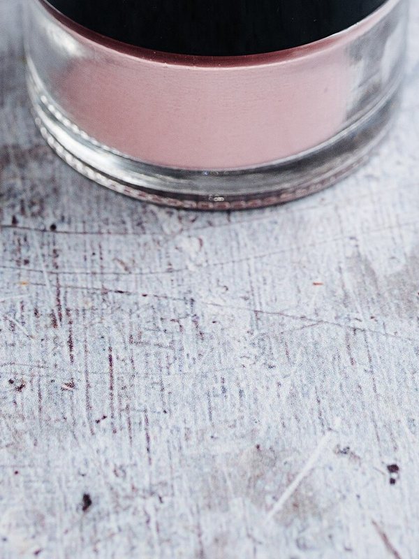 Close-up of a glass jar of pale pink cosmetic cream