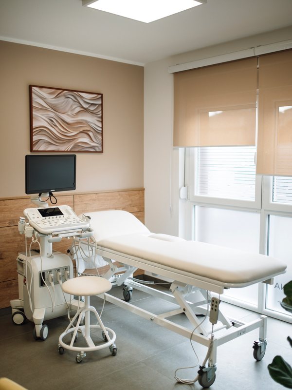 An examination room with an ultrasound unit beside a treatment couch
