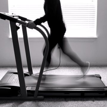 A treadmill in use, the runner blurred by motion