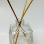 Reed diffuser sticks in a square glass bottle
