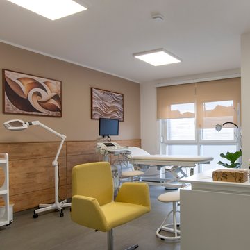Consulting room with a yellow armchair, an examination lamp and a treatment couch