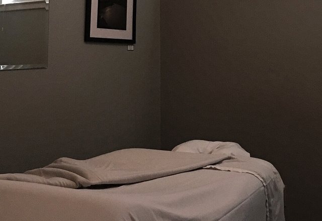 Treatment couch made up in soft linen in a quiet, low-lit room