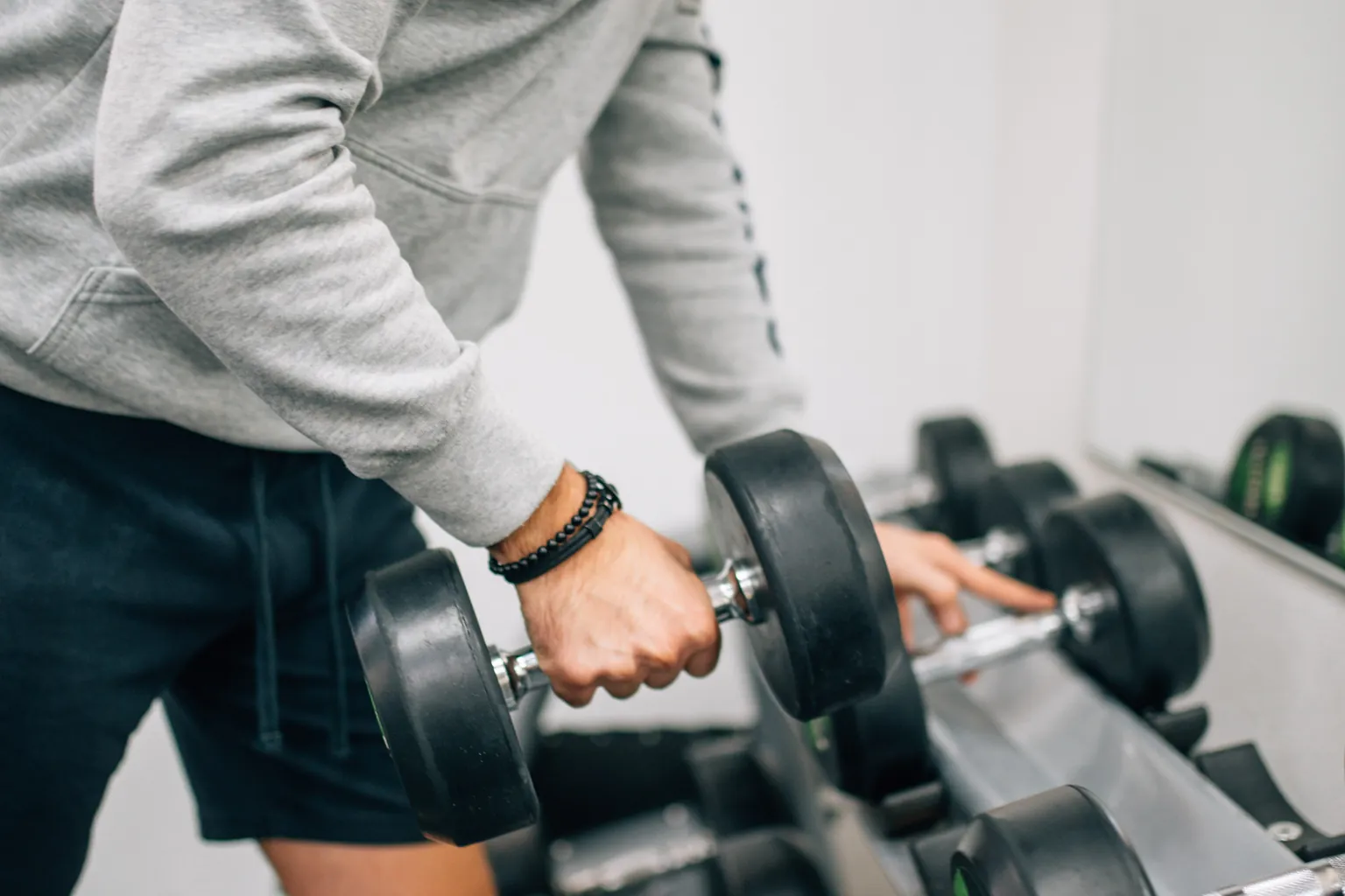 Anonymous lifter working a set in a bright strength studio
