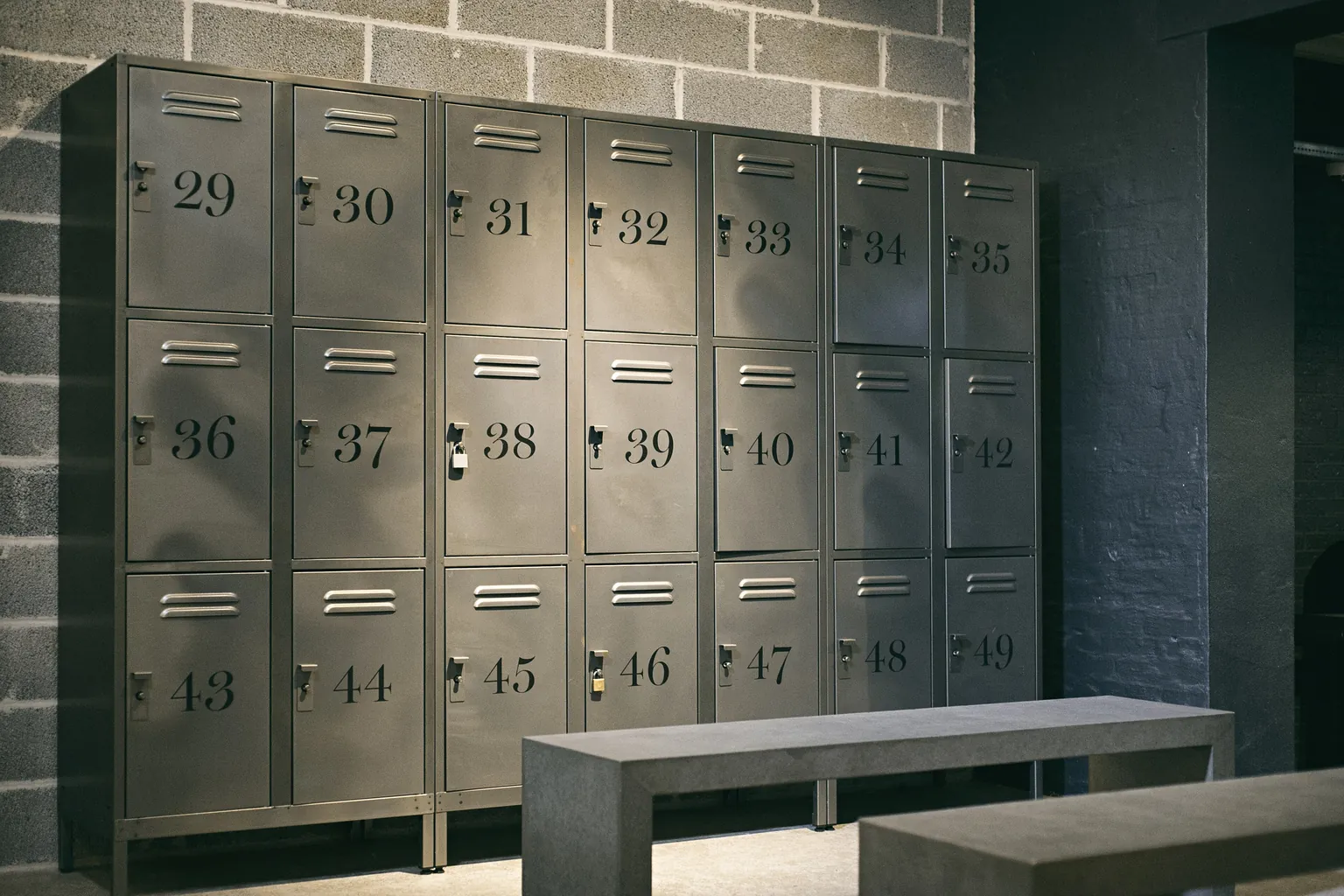 Private changing area with numbered lockers and a bench