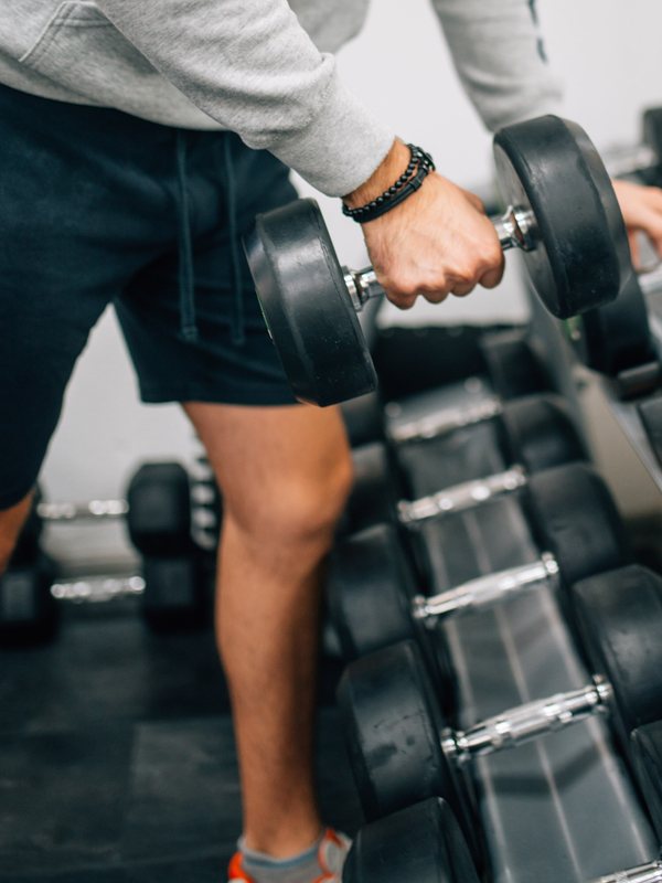 A member lifting a dumbbell off the rack during an open-gym session