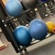 Exercise balls stacked on a two-tier storage rack in the corner of the studio