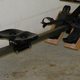 The sliding seat, rail and strapped footplates of an indoor rowing machine