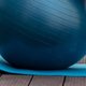 A blue stability ball resting on an exercise mat
