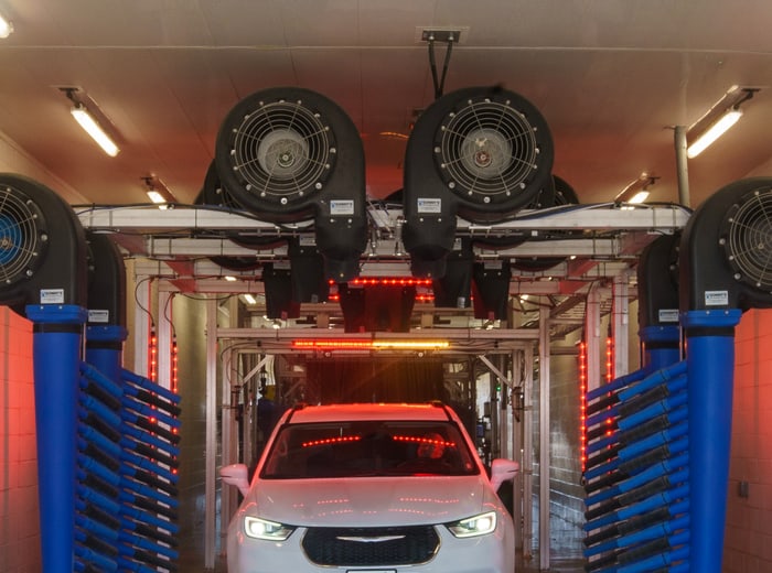 A car under the blower arch at the end of the tunnel, water being driven off