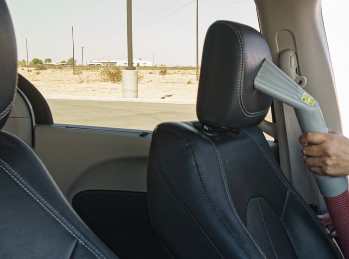 A vacuum nozzle worked down the seat bolster during an interior clean