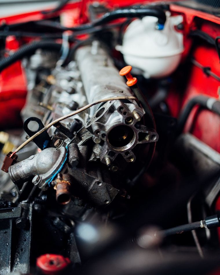 An engine bay with the top of the engine opened up, the cylinder head and valve gear exposed during an inspection.