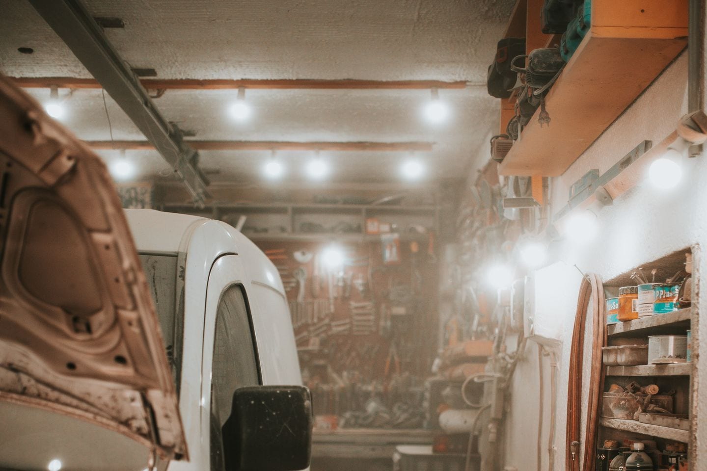A car body panel being sanded back with a grinder in preparation for paint.