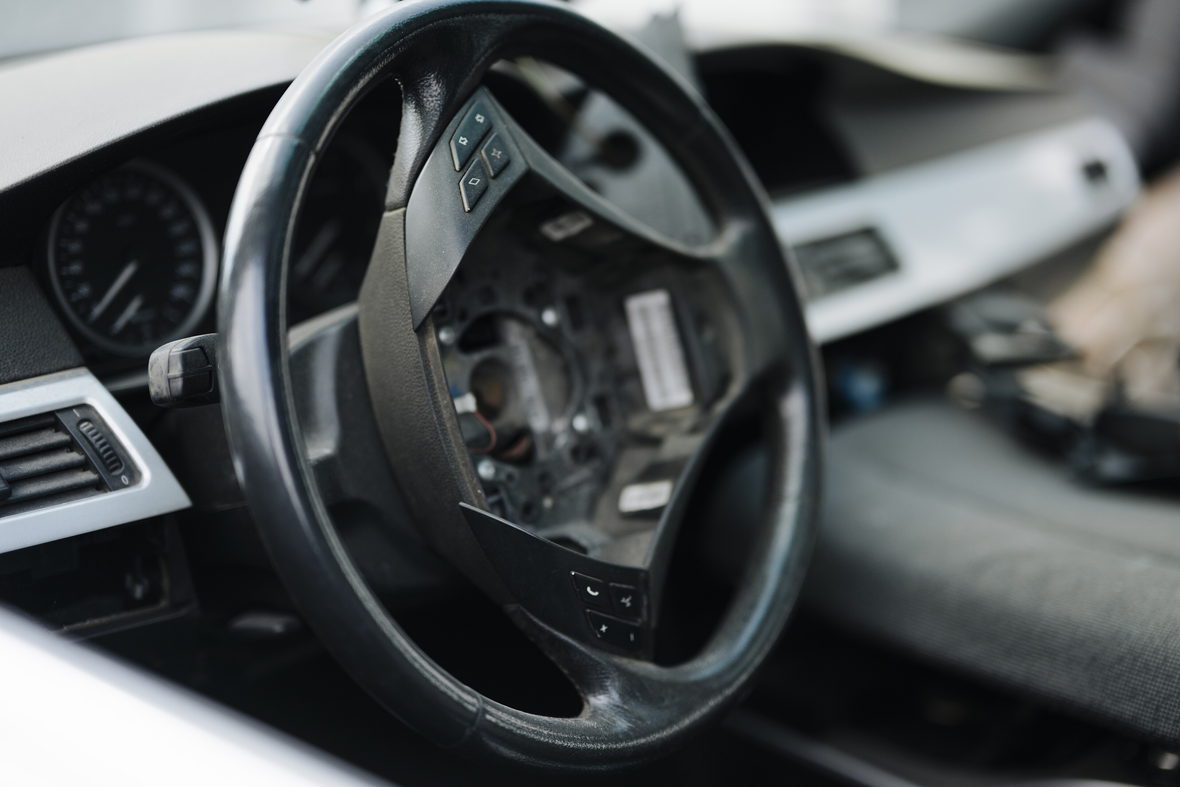 A car interior showing the steering wheel and instrument panel.